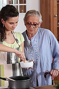 Young woman cooking with her grandmother