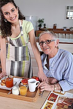 Senior woman being served breakfast at home