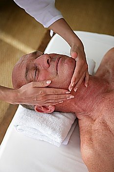Elderly man receiving a head massage