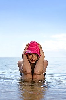 Woman in hat sitting in the sea