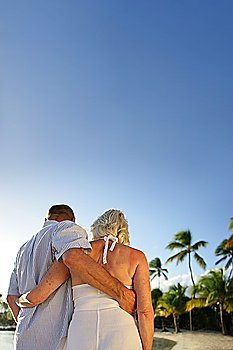 Middle-aged couple walking along beach