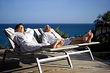 Senior couple on sun lounger whilst on holiday