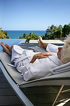 Senior couple relaxing poolside