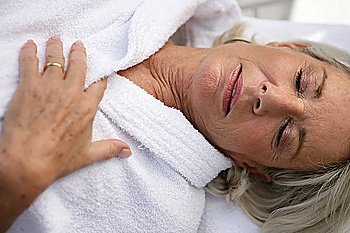 Elderly lady wearing bathrobe relaxing