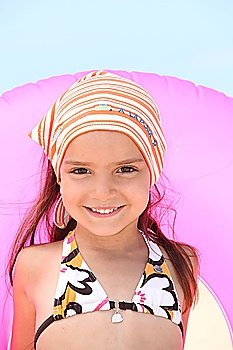 Little girl at the beach with inflatable rubber ring
