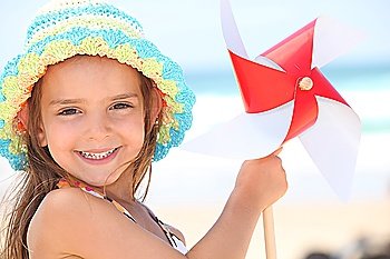 Little girl playing with wind toy on beach