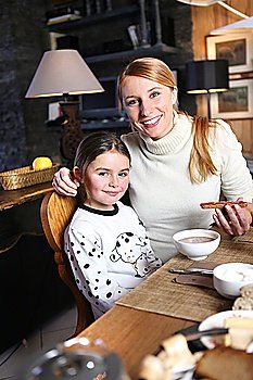 Mother and daughter eating breakfast together