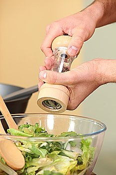 man seasoning a salad