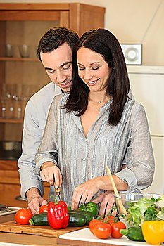 Couple cutting vegetables in a kitchen