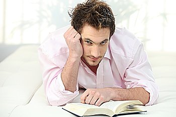 Man reading a book in bed