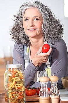 Woman with fresh tomatoes and a jar of pasta