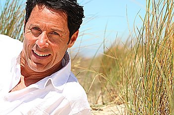 Man smiling on the beach.