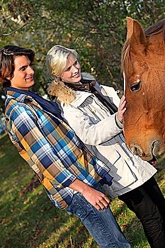 Couple standing by a horse