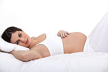 Pregnant woman laying on bed