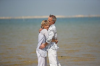 A couple embracing by the water