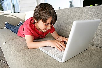 Boy using a laptop on the sofa