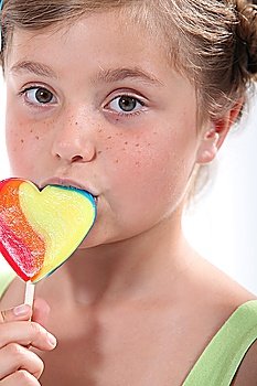 Happy little girl holding lollipop