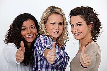 Three happy girls with thumbs up