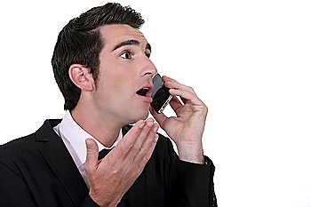Shocked businessman with mobile telephone