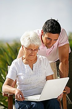 Senior woman and young man watching a laptop
