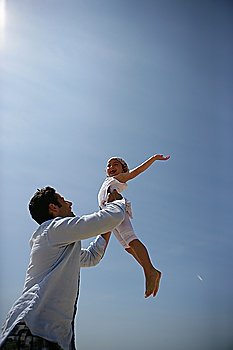 Father lifting his daughter up into the sky