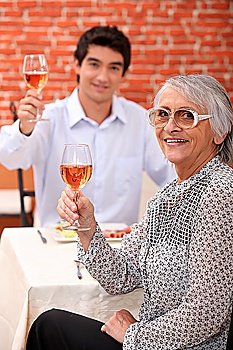 Grandmother and young man drinking rose wine