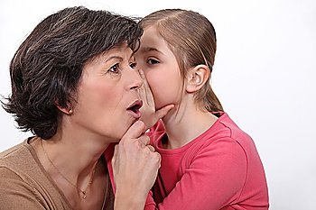 little girl telling her mother a secret