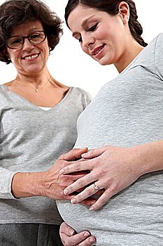 young pregnant woman and mother laying hand on her belly