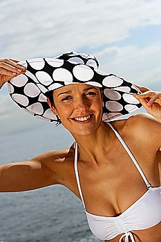 Woman wearing hat and bikini at the beach