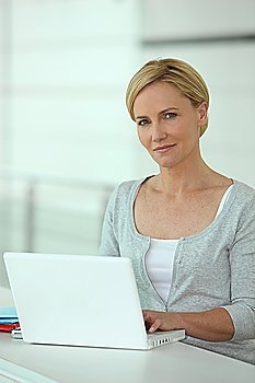 Woman working at a white laptop computer