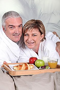 middle-aged couple having breakfast in bed