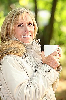 mature woman having coffee outdoors