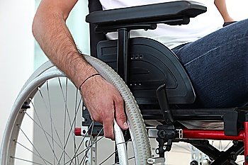 Closeup of a man´s hand on the wheel of his wheelchair