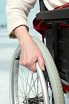 Close-up of a woman´s hand on the wheel of her wheelchair