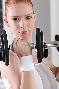 A determined woman lifting a dumbbell