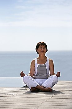 Woman doing yoga by the waterfront