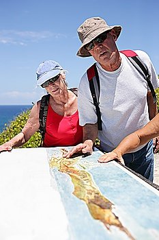 Hikers looking at a map by the coast