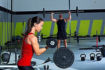 girl dumbbell and man weight lifting bar workout  at crossfit gym