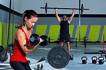 girl dumbbell and man weight lifting bar workout  at crossfit gym