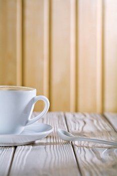 white coffee cup and spoon on old table