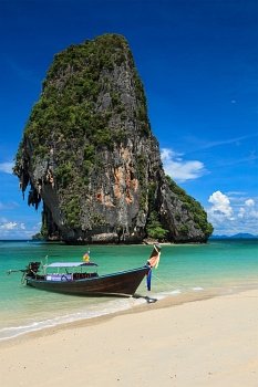 Long tail boat on tropical beach with limestone rock, Krabi, Thailand