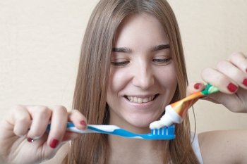 Closeup on woman´s toothy smile brushing her teeth