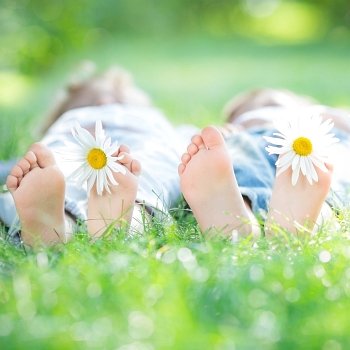 Family lying on green grass in spring park. Healthy lifestyle concept