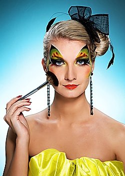 Beautiful woman with creative face-art and make-up brush