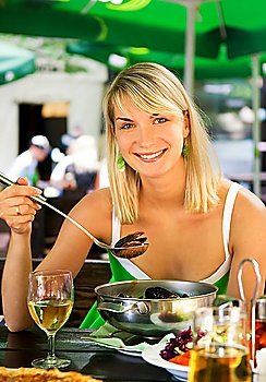 Beautiful young woman eating seafood in a restaurant