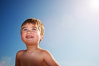 Smiling baby against blue sky.