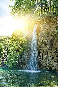 Sunrise over waterfall in wild forest