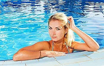 Beautiful blond woman relaxing in a pool