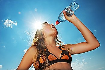 Young girl drinking water outdoors