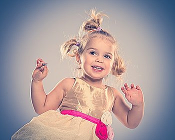 Happy little girl in dress isolated on grey